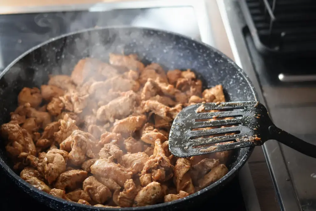 Hähnchenfleich wird in der Pfanne gebraten