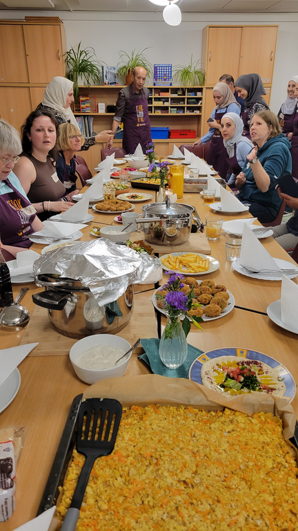 Die Gäste sitzen am reichlich gedeckten Tisch mit verschiedenen Speisen.