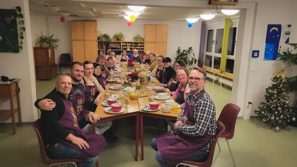 Alle Personen sitzen an der gedeckten Tafel